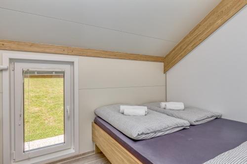 a small bedroom with a bed and a window at Three Stars Luxury House ART-PE with pool and SPA pool in Trebnje