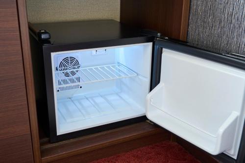 a refrigerator with its door open in a room at Hotel Axia Inn Sapporo Susukino in Sapporo