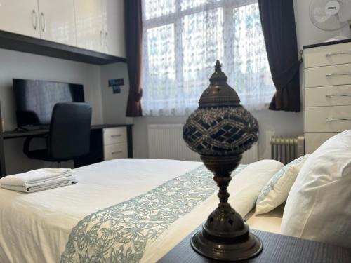 a bedroom with a bed with a lamp on a table at Deluxe Homestay near Tottenham Hotspur Stadium in London