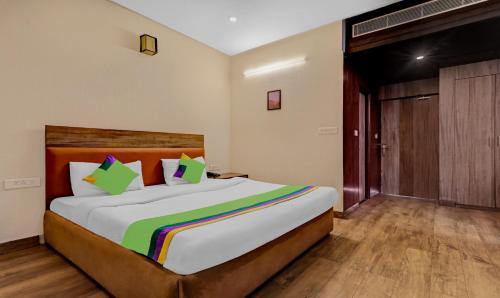 a bedroom with a large bed with a colorful blanket at Treebo Edesia in Lucknow