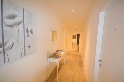 a hallway with a table and paintings on the wall at Affittacamere Casa Dane' in La Spezia
