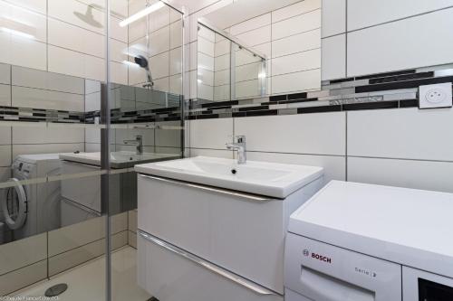 W białej łazience znajduje się umywalka i lustro. w obiekcie Gîte de la Combe Farbet w mieście Darcey