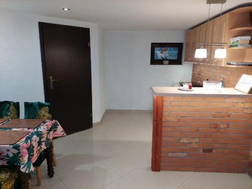 a room with a kitchen with a table and a black door at Mazurska Piwniczka in Giżycko