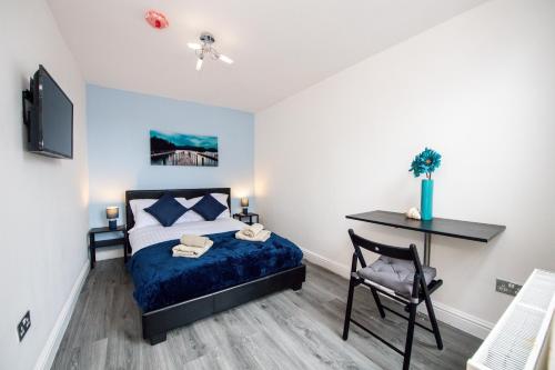 1 dormitorio con cama, escritorio y silla en Five Seasons Liverpool City - Modern Studios near Anfield en Liverpool