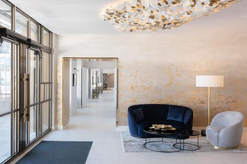 a living room with a blue chair and a chandelier at Fleur de Loire in Blois