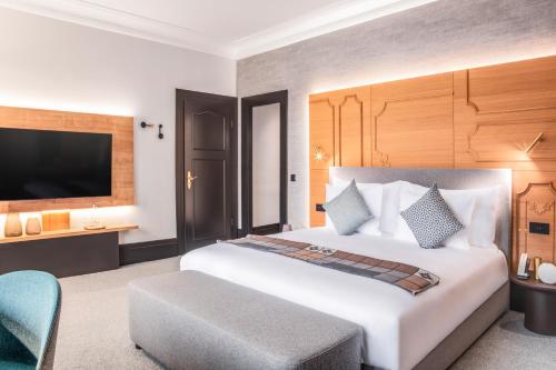 a hotel room with a bed and a tv at Villars Palace in Villars-sur-Ollon