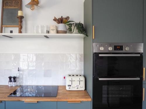 a kitchen with a stove and a black oven at Coorie Away - Kirkcudbright in Kirkcudbright