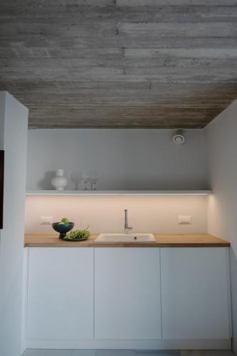 a kitchen with a sink and a wooden ceiling at Domino Syros by SV in Ermoupoli