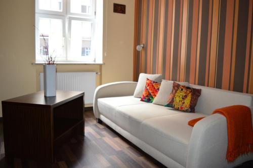 een woonkamer met een witte bank en een raam bij Parlament in Gdańsk