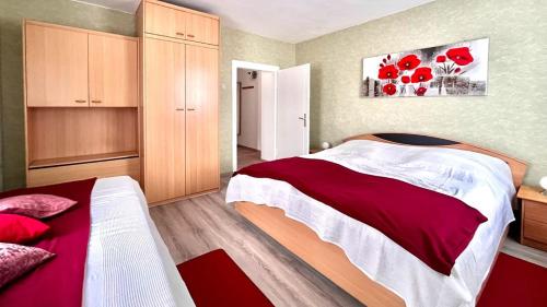 1 dormitorio con 2 camas y una pintura de flores rojas en Ferienwohnung Bodenstein, en Bad Liebenstein