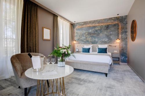 a hotel room with a large bed and a table at Fleur de Loire in Blois