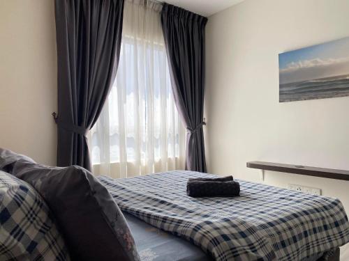 1 dormitorio con 1 cama con manta y ventana en 【NETFLIX】Suasana Suites,Nxt to CIQ【PoolGym&WIFI】, en Johor Bahru