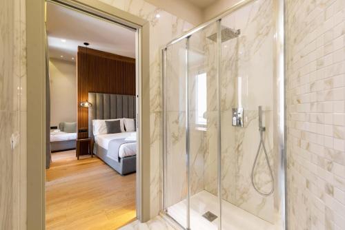 bagno con doccia e porta in vetro di ELICAL Exclusive Private Suites a Roma