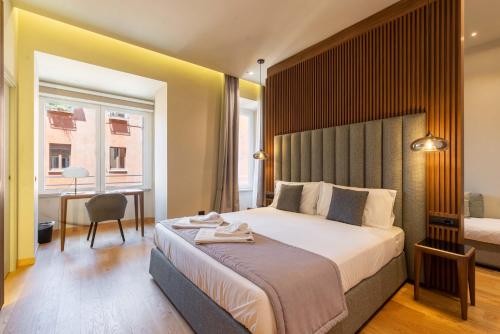 um quarto com uma cama grande e uma secretária com uma cadeira em ELICAL Exclusive Private Suites em Roma