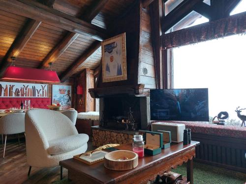 a living room with a table and a fireplace at Baita LE SERE in Sestriere