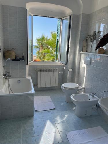 een badkamer met een bad, een toilet en een wastafel bij Maniman in Varazze