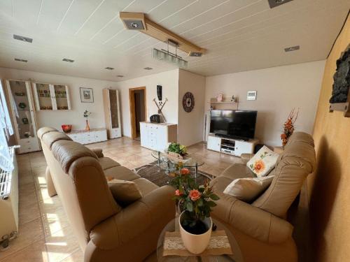 ein Wohnzimmer mit Sofas und einem Flachbild-TV in der Unterkunft Ferienwohnung "Auszeit" mit Garten in Riedlhütte