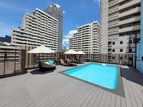 a swimming pool on top of a building with buildings at Citrus Suites Sukhumvit 6 by Compass Hospitality in Bangkok
