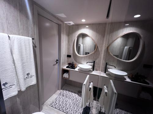 a bathroom with two sinks and two mirrors at Casas Bouça Maria - Aqua Village & Sports in Marco de Canaveses
