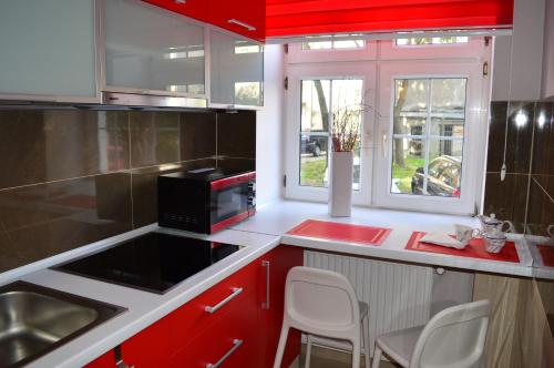 een keuken met rode en witte kasten en een magnetron bij Parlament in Gdańsk
