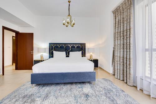 een slaapkamer met een groot bed en een kroonluchter bij Great Family apartment near the JBR beach in Dubai