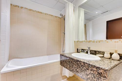 een badkamer met een wastafel en een bad bij Great Family apartment near the JBR beach in Dubai