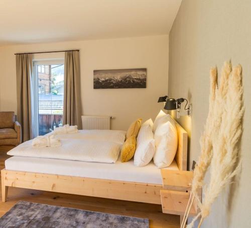 a bedroom with a bed with white sheets and pillows at Hotel Alpin Tyrol - Kitzbüheler Alpen in Sankt Johann in Tirol