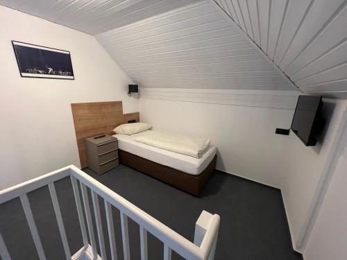 a small bedroom with a bed and a television at Hotel Am Tiergarten in Nürburg