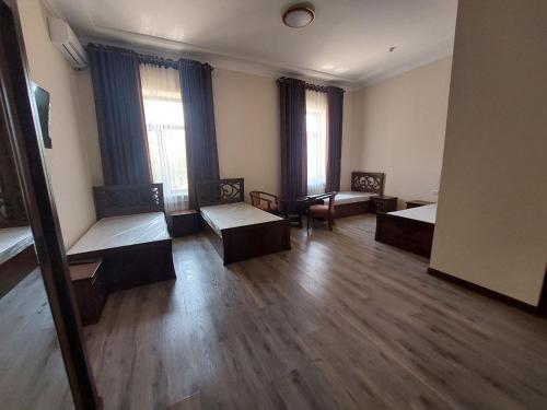 pokój z 2 łóżkami i krzesłami w obiekcie Samarabonu Hotel w Samarkandzie