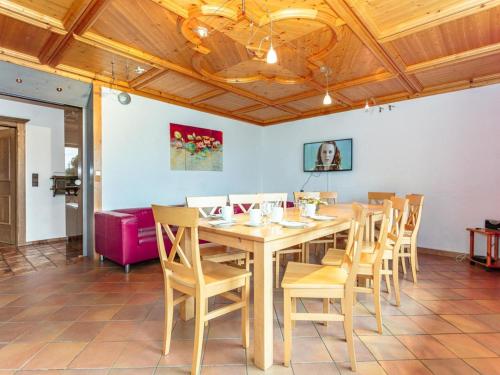 comedor con mesa de madera y sillas en Great group holiday home en Neukirchen am Großvenediger