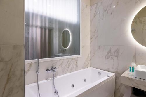 a bathroom with a tub and a sink and a mirror at ELICAL Exclusive Private Suites in Rome