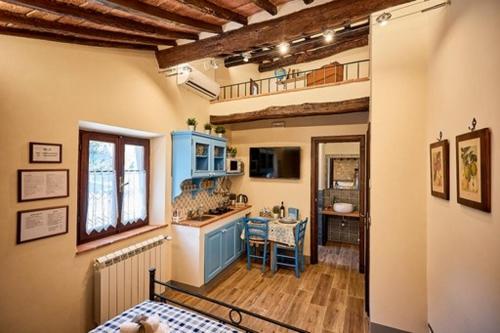 una cocina con armarios azules y una mesa en una habitación en La casina di Iole en Montepulciano