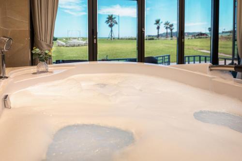 a jacuzzi tub with a view of a field at Sun and Moon Resort in Seogwipo