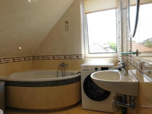 a bathroom with a tub and a sink and a window at Wypoczynek na Mazurach u Kamili in Konopki Wielkie