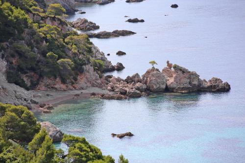 an island with a beach with a person with an umbrella at Apartment Zuljana 4576a in Žuljana