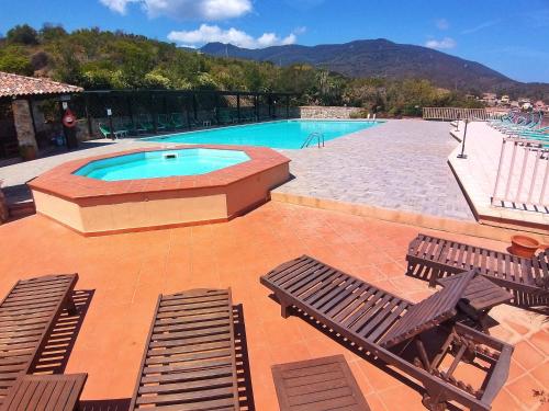 - une piscine avec 2 chaises longues dans l'établissement Al Barcoco, à Marina di Campo