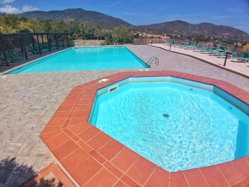 a large swimming pool with blue water in a resort at Al Barcoco in Marina di Campo