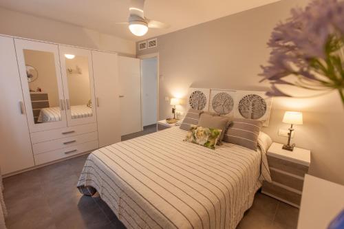 a bedroom with a large bed and a mirror at La playa a tu alcance in Salobreña