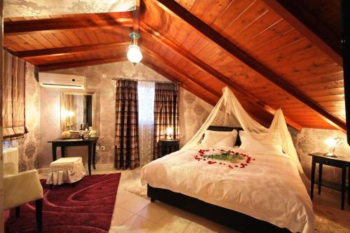 a bedroom with a white bed with a wooden ceiling at Palatino Rooms & Apartments in Tripolis