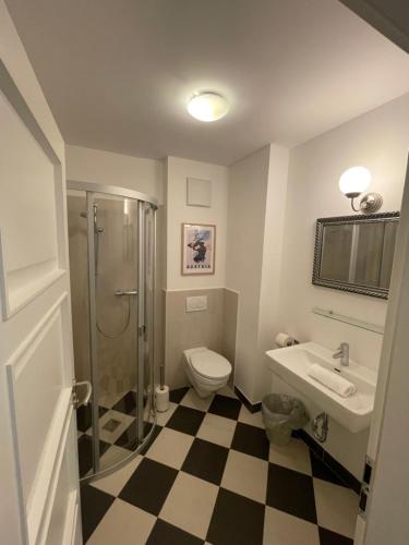 a bathroom with a shower toilet and a sink at Alpenhof by AlpenTravel in Bad Gastein