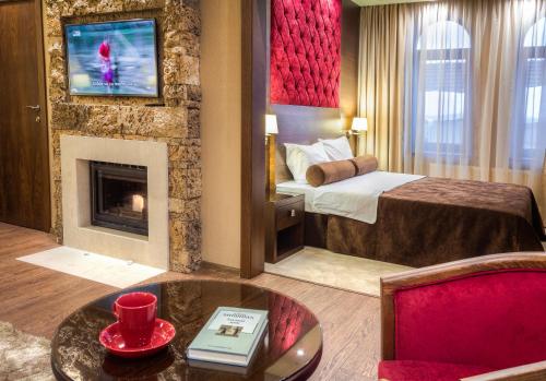 a hotel room with a bed and a fireplace at Family Hotel Strannopriemnitza in Oreshak