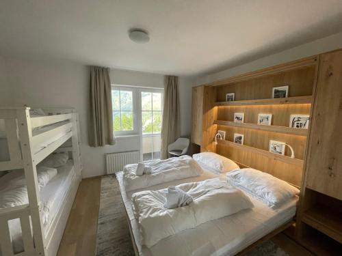 een slaapkamer met 2 stapelbedden en een raam bij Alpenhof by AlpenTravel in Bad Gastein