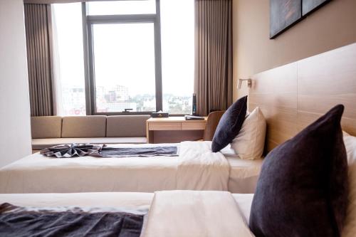 a hotel room with two beds and a large window at KOVIE HOTEL in Ðoan Xá
