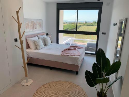 a bedroom with a bed and a large window at Casa Flamencos in Rojales