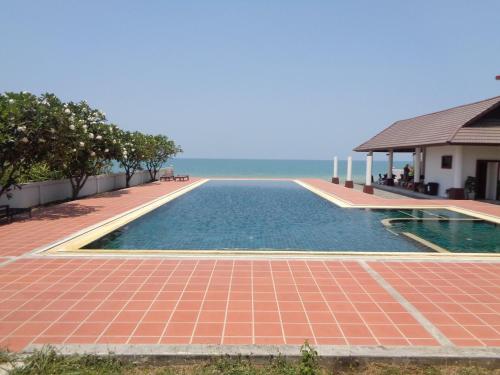 a swimming pool with the ocean in the background at 2-Bedroom Khanom Beach Ocean Front Condo in Khanom