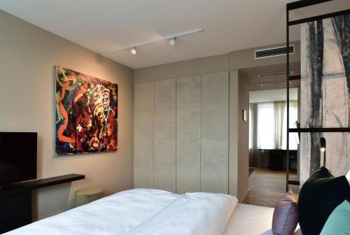 1 dormitorio con una gran pintura en la pared en SAXX Hotel "Am Theater Karree" en Hagen