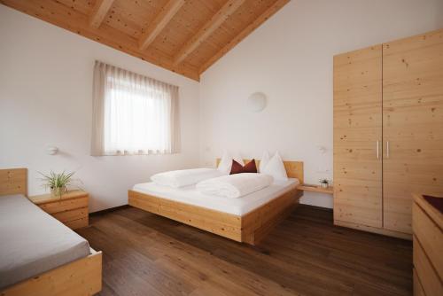 a bedroom with two beds and a window at Untermairhof Appartment Residence in Selva dei Molini