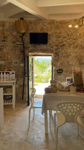 a room with a stone wall with a table and a window at Feudo Frammasi - Curte Glamping Experience in Salve