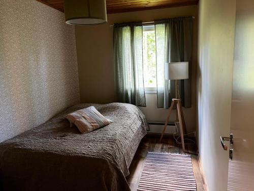a bedroom with a bed and a window at Minttu in Orivesi