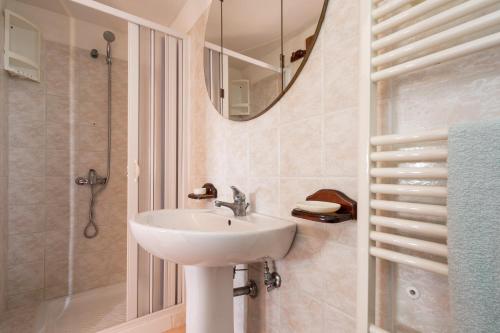 un bagno con lavandino, doccia e specchio di Villa Relax a Galatone